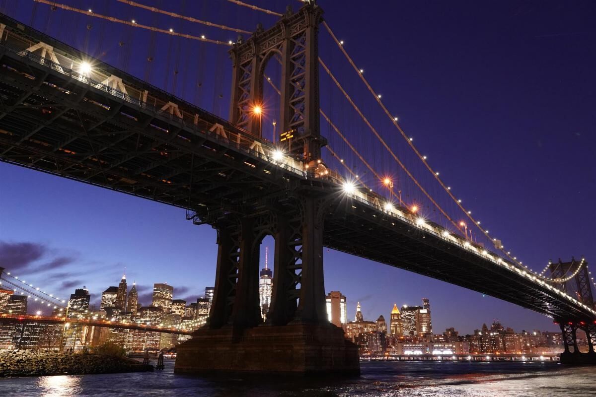 Brooklyn Bridge and surrounding city lit up at night, photographed with the Sony a7III mirrorless camera