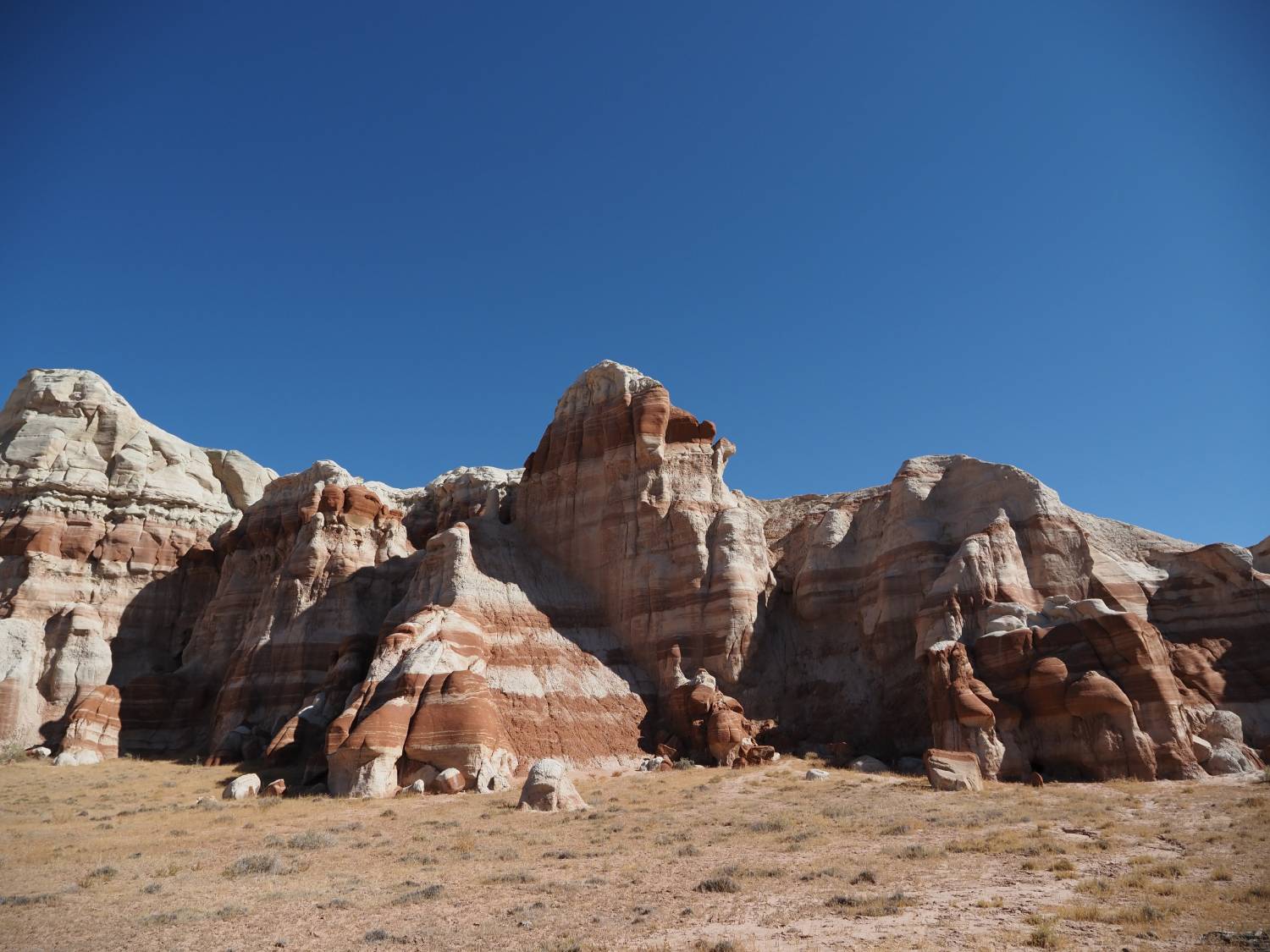 Striped rock formations beneath clear blue sky, shot with Olympus 12-45mm f4 PRO Lens