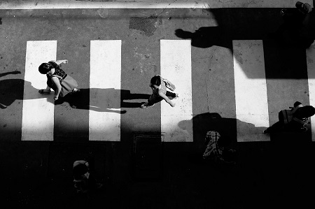 black and white photo of people walking on a pedestrian lane