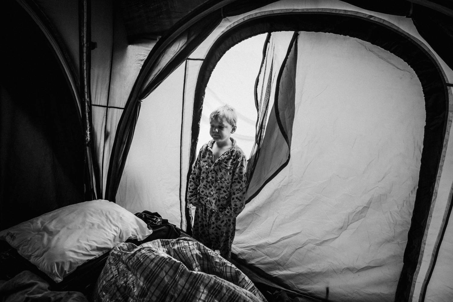 a boy standing inside a tent