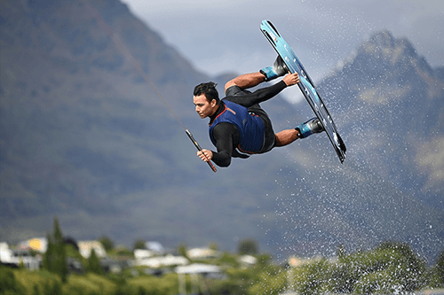 Kite surfer photographed mid-air against mountains in the background, photographed using the Nikon Z 70-200mm f2.8 VR S lens