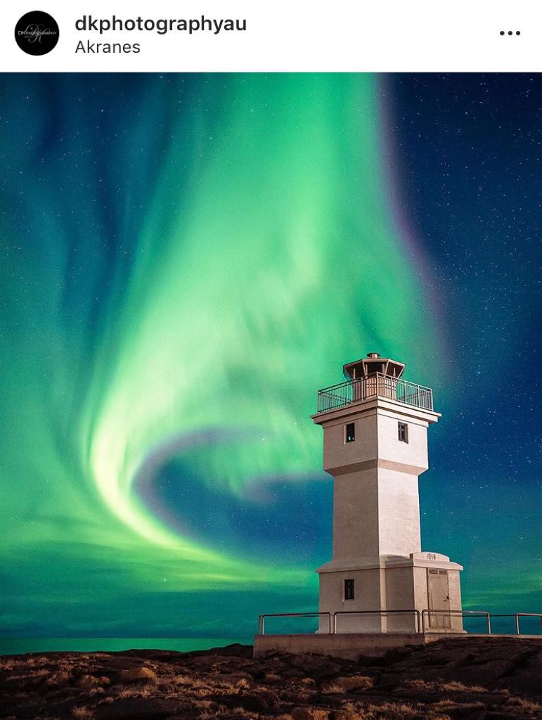 white light house and luminous aurora in the background