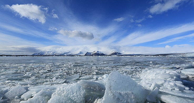 Arctic seascape with ice-filled water beneath a cloudy blue sky, photographed with the Canon 16-35mm f4 lens