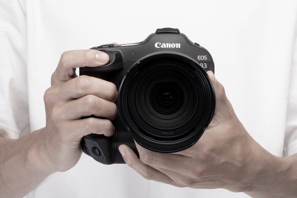 A man holding a Canon EOS R3