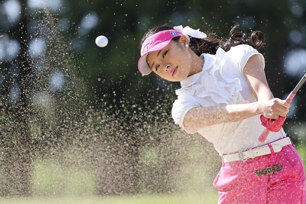 Female golfer watching a ball as she completes her swing, photographed with the Canon RF 100-500mm f4.5-7.1 L IS USM Lens