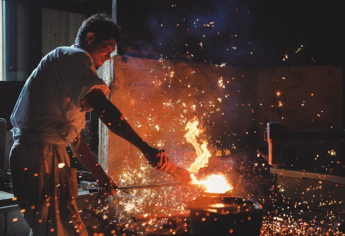 Sparks flying around a Japanese sword maker forging a blade, photographed with the Canon RF 24-105mm f4 IS USM lens