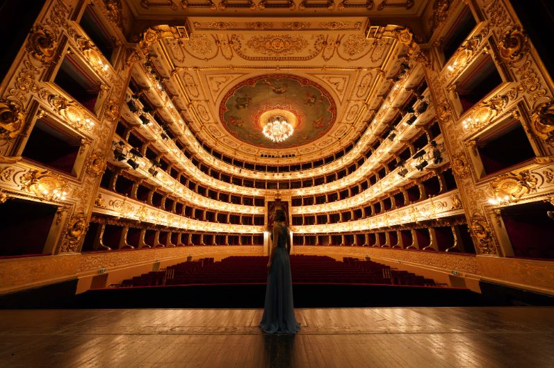 Young woman in blue gown standing on the stage of Teatro Regio in Parma, Italy, photographed with the Sony 12-24mm f2.8 GM lens