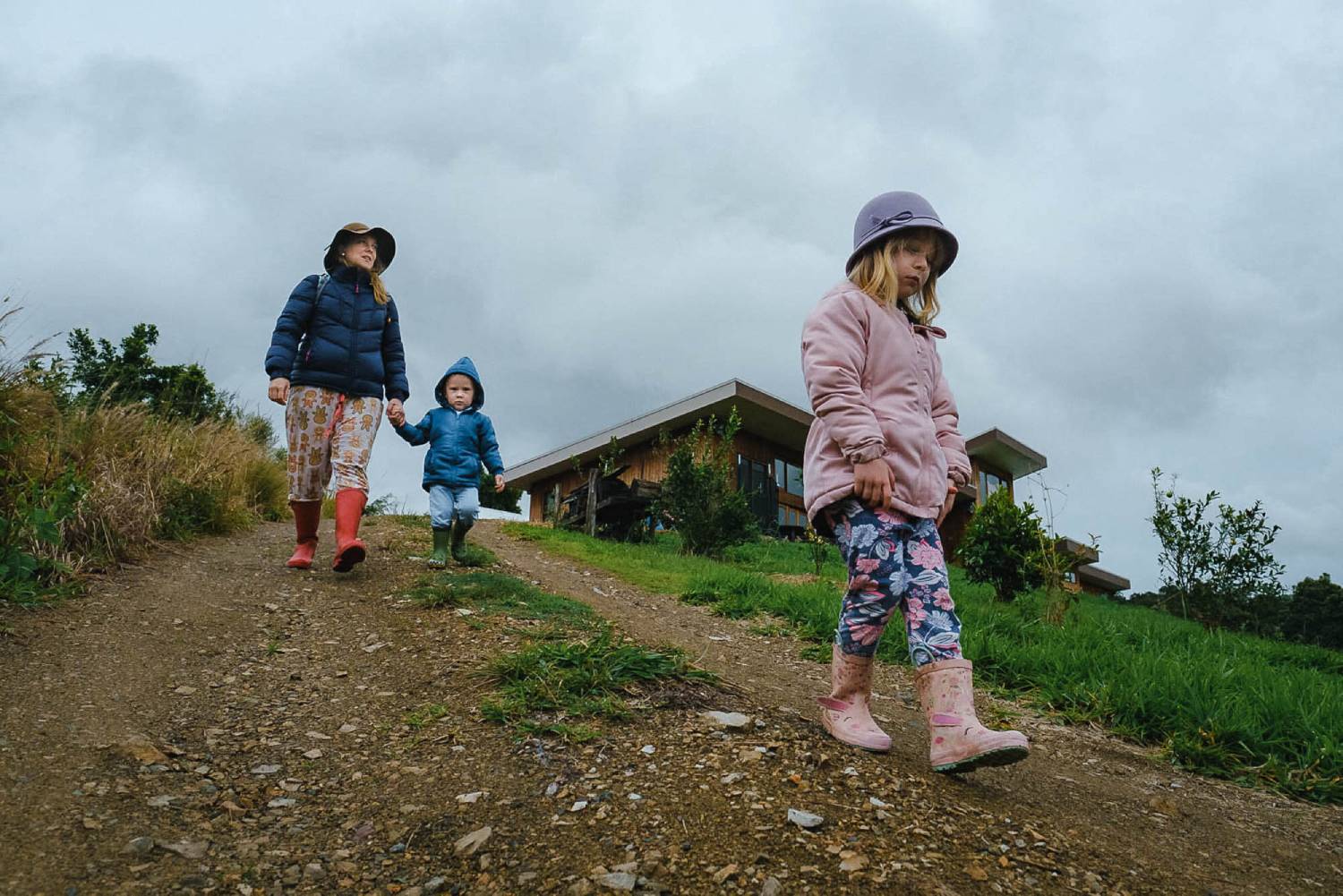 a mother and her two children walking down the hill