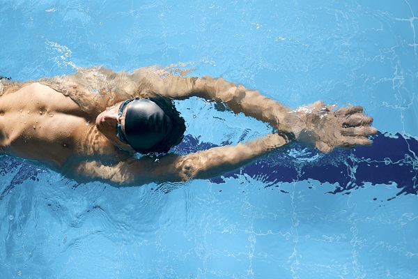 Male swimmer gliding head-up through the water of a swimming pool, photographed with the Fujifilm GF 30mm f3.5 R WR lens