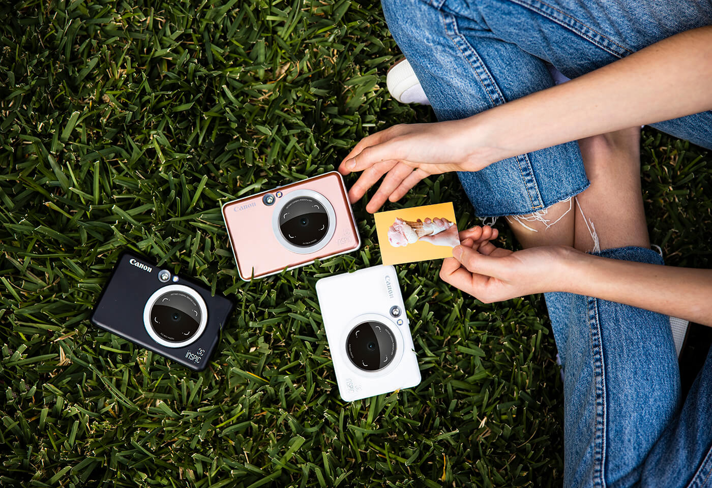 various canon inspic cameras laid out on the grass