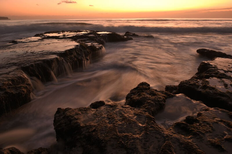 Sunset by the rocky shore, taken using the Nikon 24mm f/1.8 lens