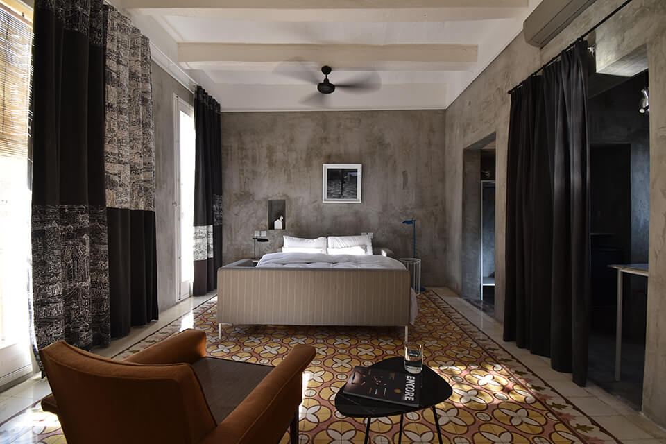 Stylish modern hotel room interior with concrete grey walls and retro tiled floor, photographed with the Nikon 10-20mm DX VR AF-P lens