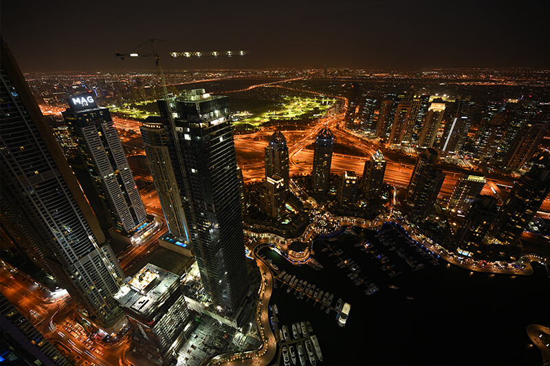 View over Dubai city buildings and waterfront at night, photographed with the Nikon Z 14-30mm lens