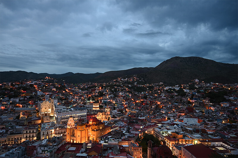 Guanajuato in Mexico lit up at twilight beneath grey clouds, photographed with the Nikon NIKKOR Z 24-70mm f/4 S Lens