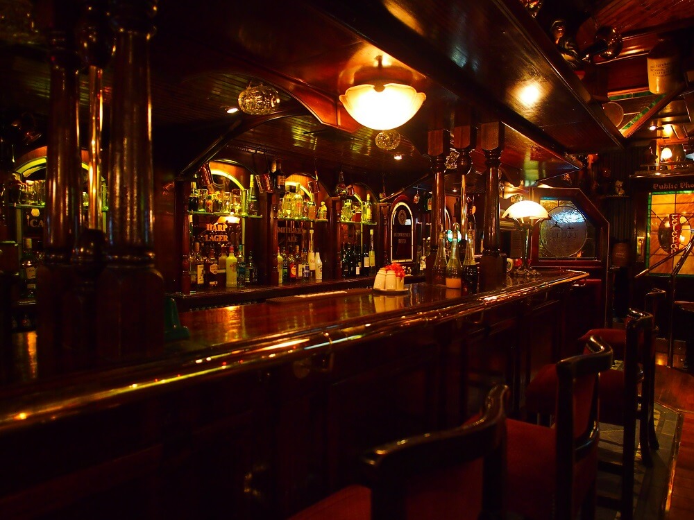 Polished dark timber bar inside a traditional English pub, photographed with the Olympus 12mm f2 lens