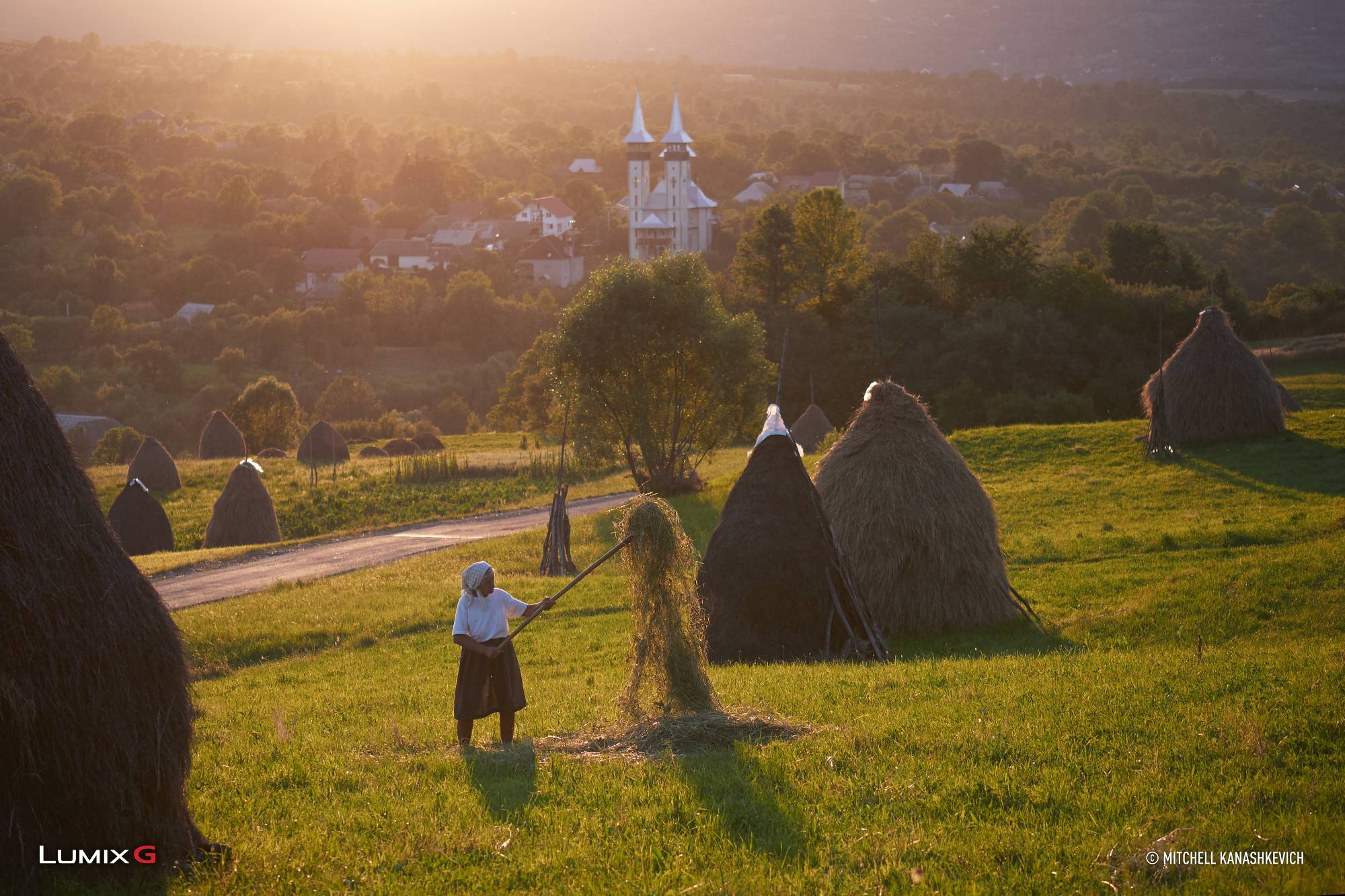 Romanian countryside at sunset with a farmer working in her field, photographed with the Panasonic LUMIX G85 camera