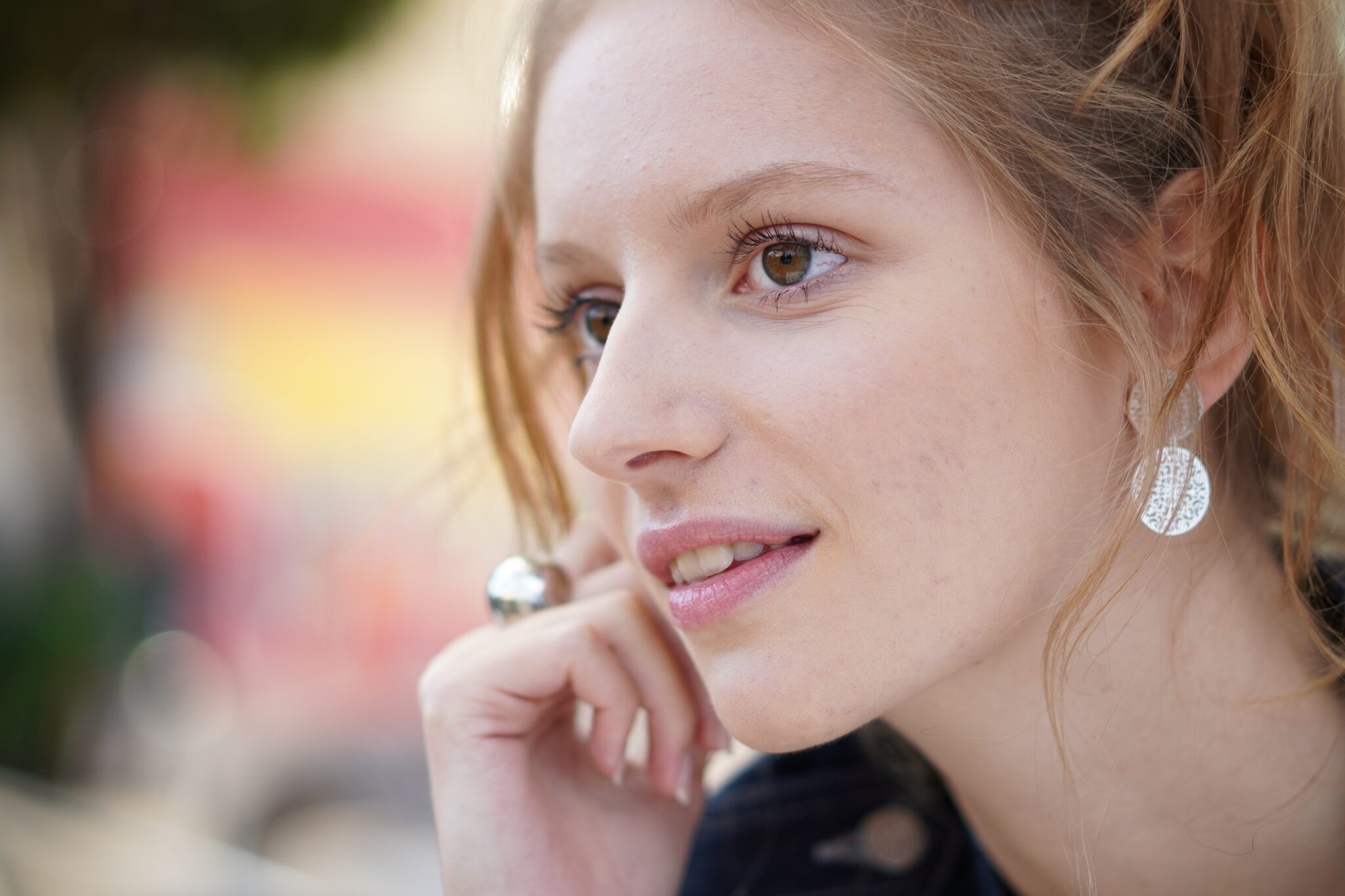 Shallow-focus portrait of young blonde woman with brown eyes, photographed with the Sony 55mm f1.8 Zeiss lens