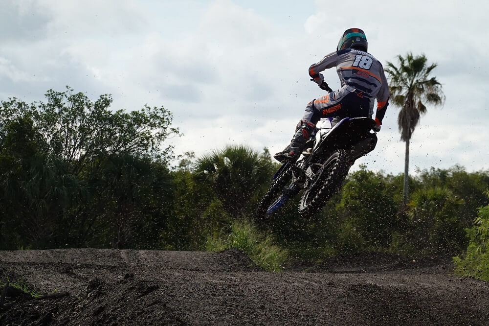 Dirt bike rider mid-air over a jump, photographed from behind with the Sony RX100 VII