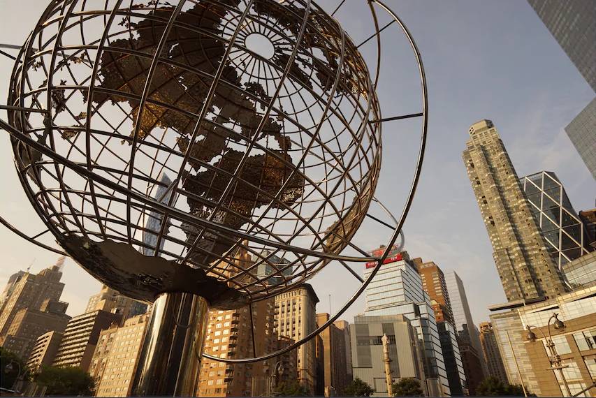 Metal globe sculpture in the foreground with skyscrapers in the background, photographed with the Sony 16-35mm f4 lens