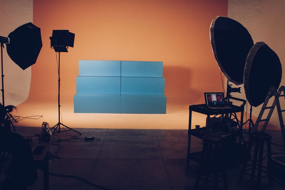 A studio photography setup with an orange backdrop