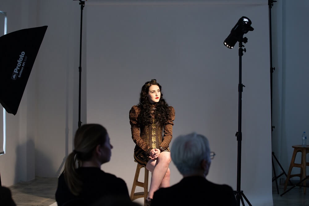 Behind the scene of a studio photography shoot with a female model