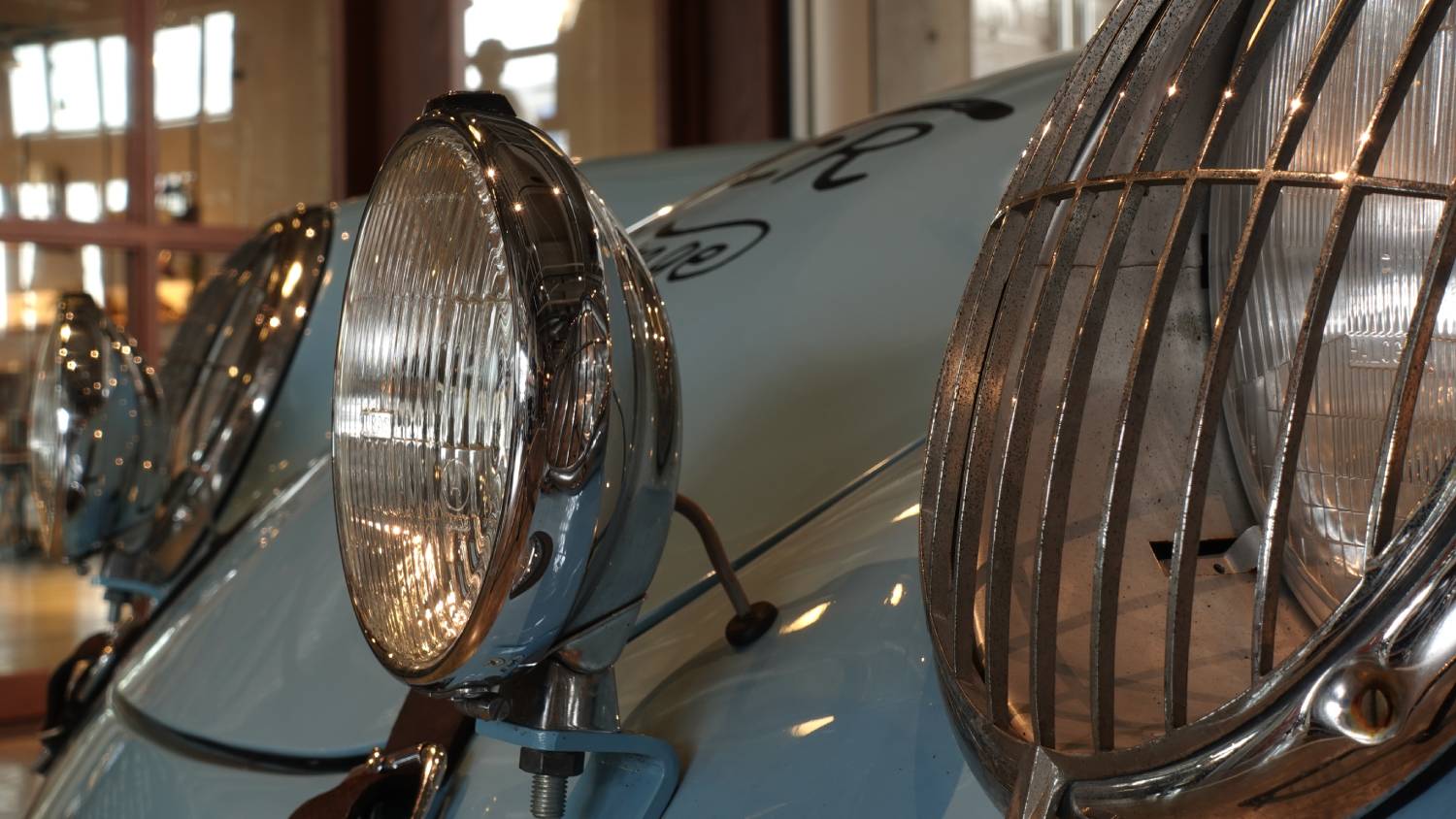 Close-up of headlights on a shiny, light blue vintage car, photographed with the Sony ZV-1 digital camera