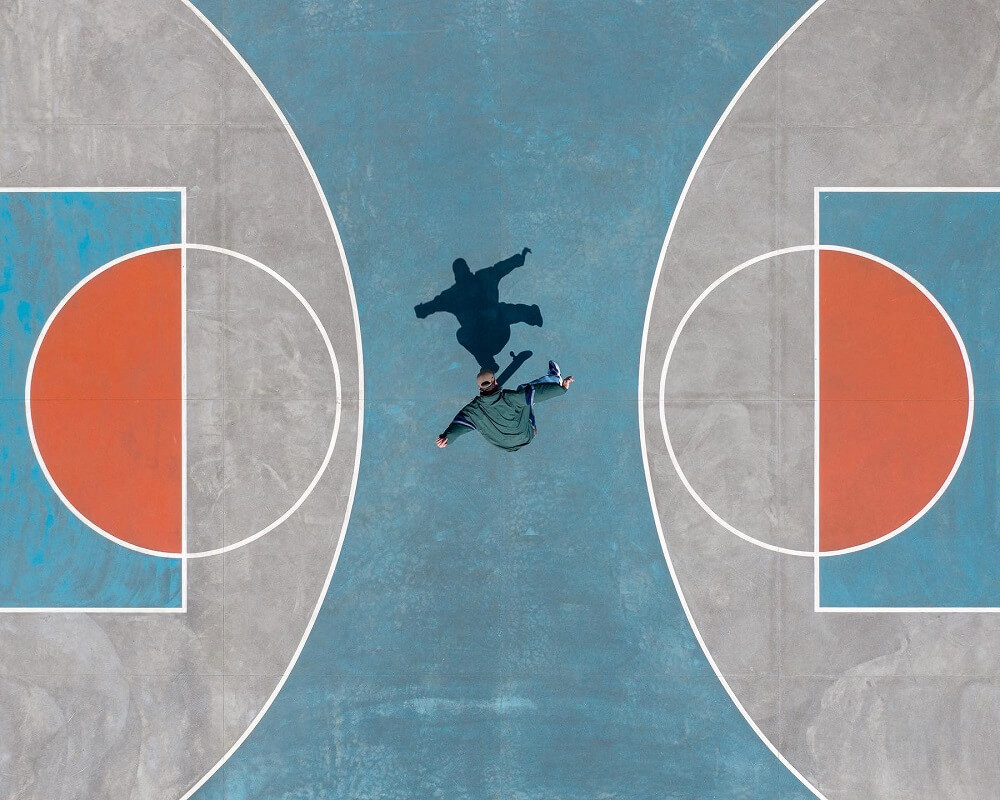 aerial photograph of a skater in a basketball court