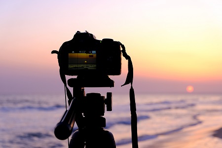 dslr camera taking a picture of the sunset