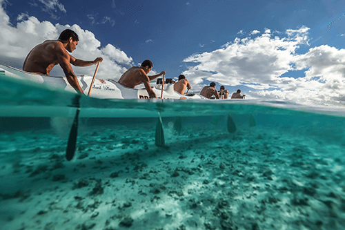 Men kayaking through shallow water, photographed half underwater on the Canon 1DX III