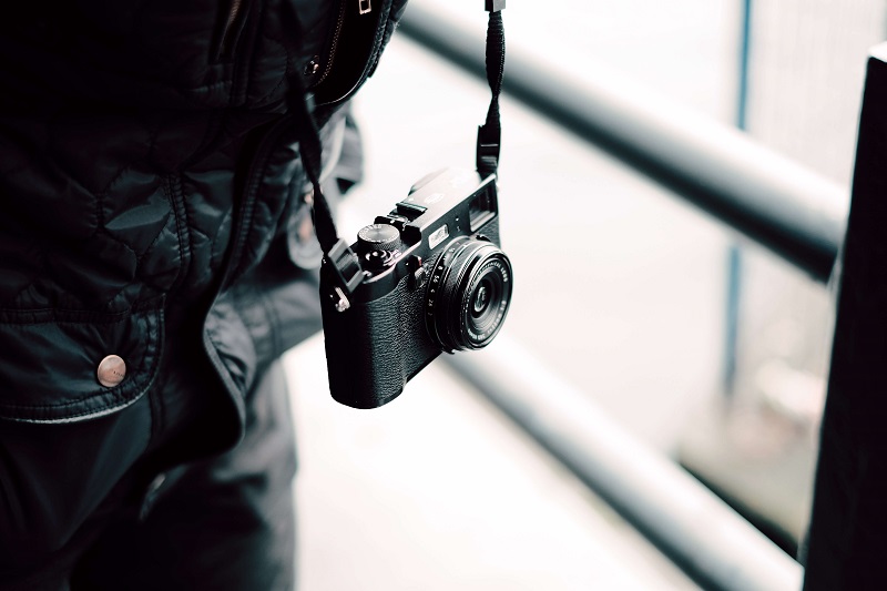 compact camera hanging on a street photographers neck