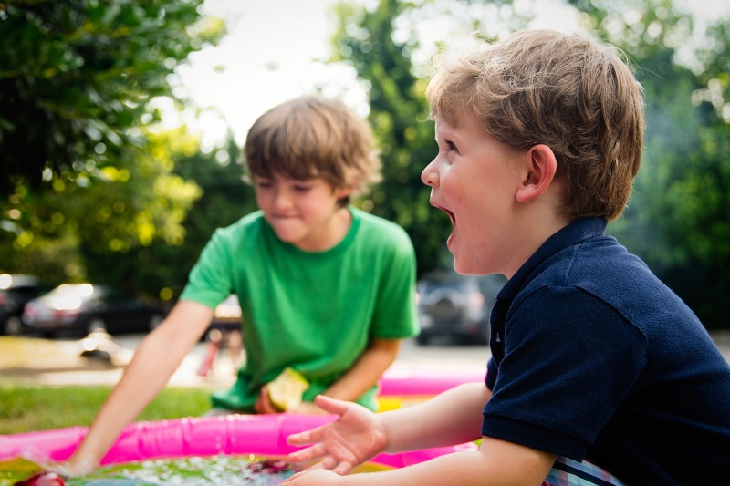 two children playing on the backyard