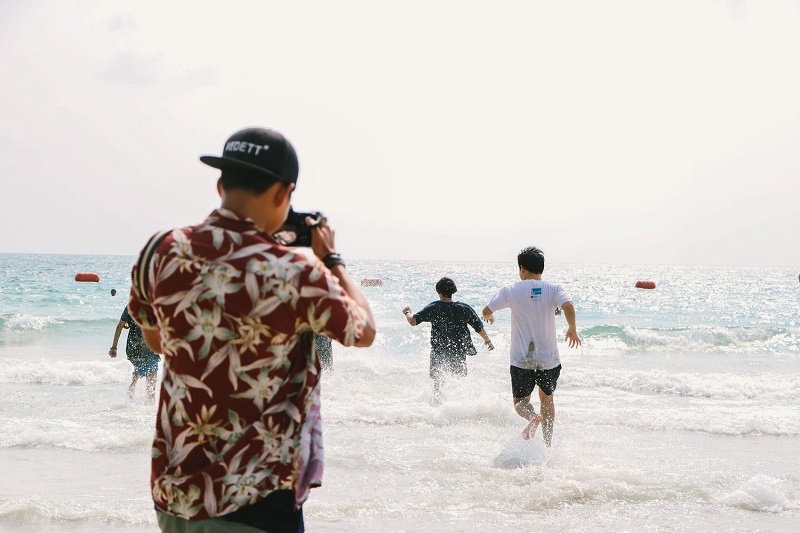 photographer taking pictures on guys running to the beach