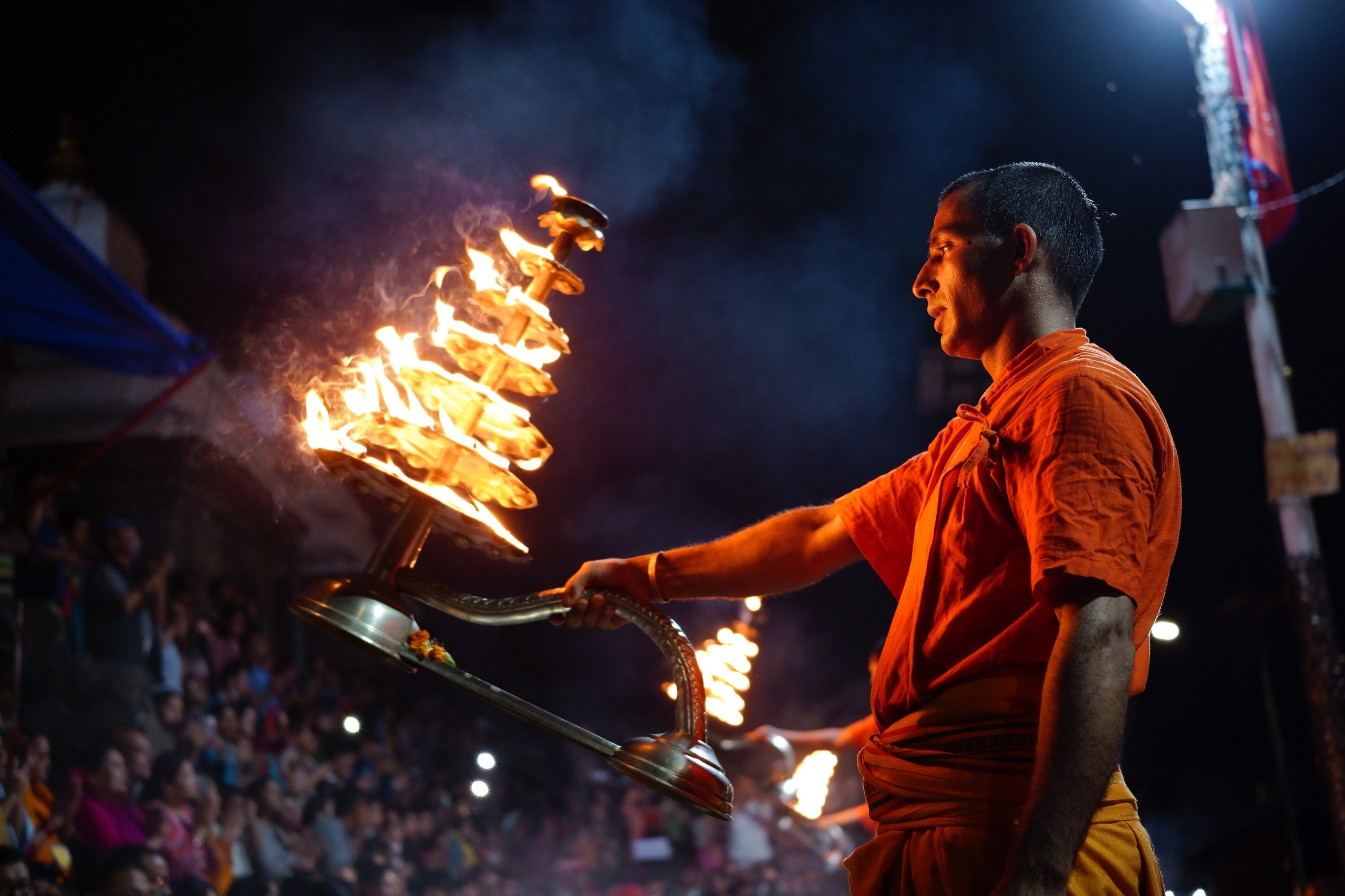 Monk waving ornate torch with crowd watching in background, photographed with the Sigma fp camera