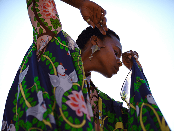 Fashion model in colourful patterned outfit posing against a bright sky, photographed with the Fujifilm GF 80mm f1.7 R WR lens