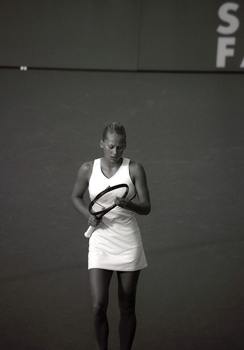 female tennis player checking her racket