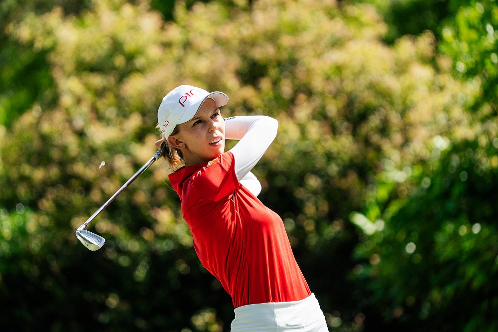 Female golfer swinging her golf club, taken by Kurt Thomson.