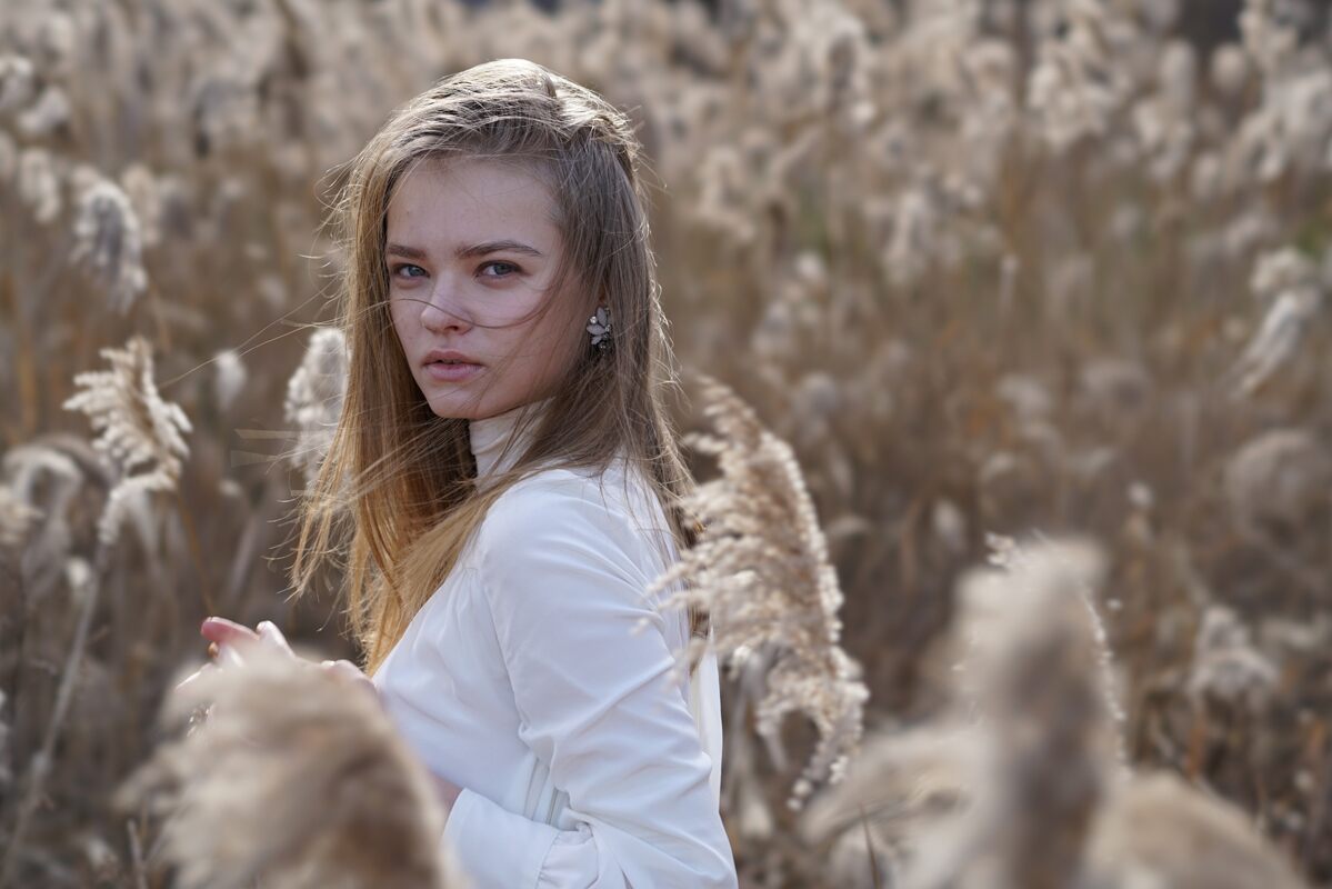 Lifestyle photo of a woman in the middle of a tall grass field