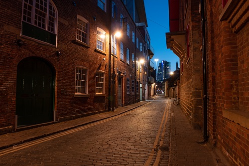 Lamplit cobbled laneway between historic brick buildings, shot with the Panasonic G100 Mirrorless Camera