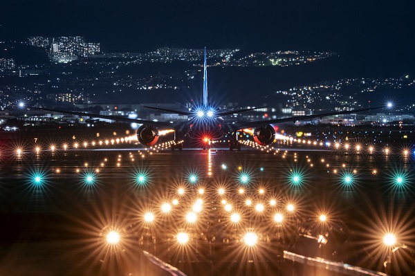 Bright lights on a runway seen from behind a landed plane, shot with the Panasonic LUMIX S 70-300mm F4.5-5.6 MACRO O.I.S. lens