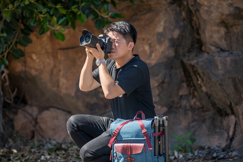 man wearing black shirt taking pictures using a dslr