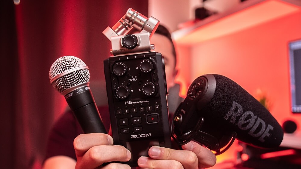 Man holding various audio recording tools