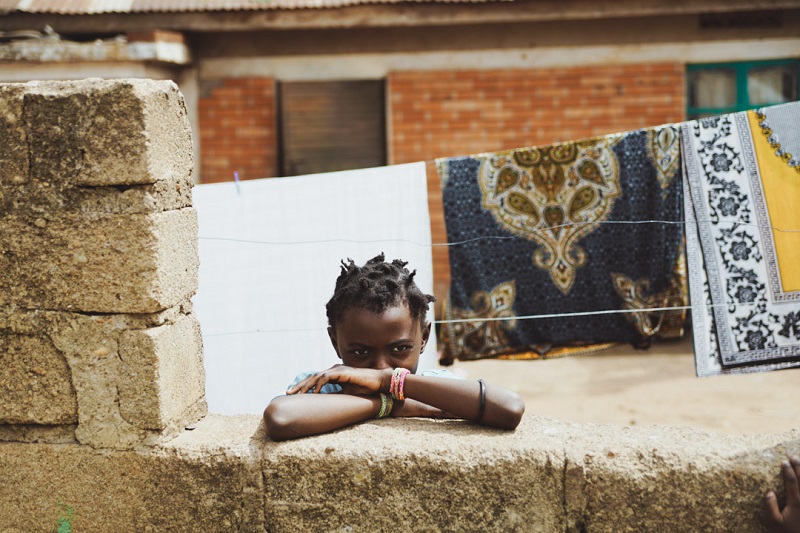 Kid in a Ugandan Orphanage Looking by the Fence