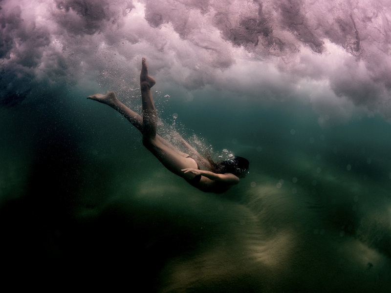 underwater photo of a woman diving in the sea