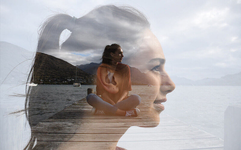 A woman on a dock, double exposed with her portrait – photographed with the Nikon D7500 DSLR camera