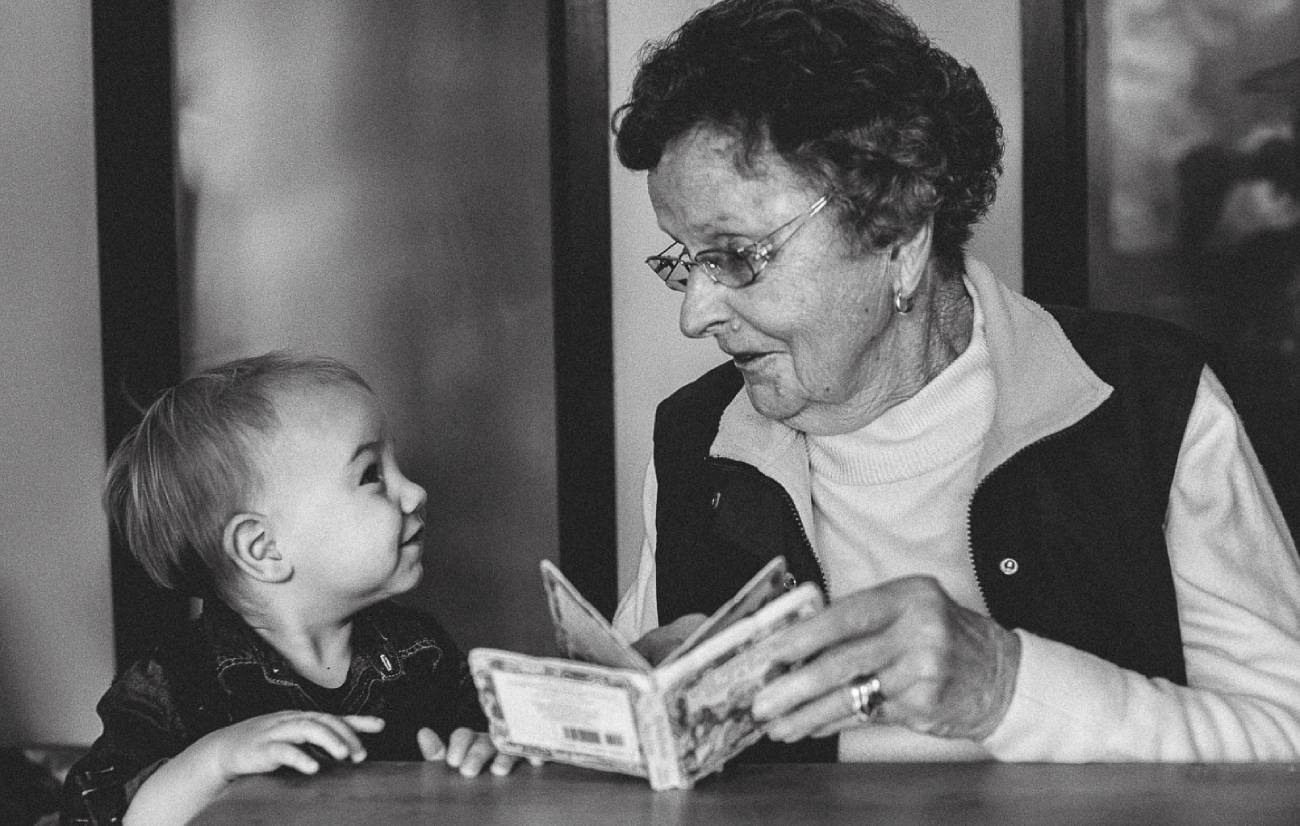 a grandmother reading a book to her grandchild