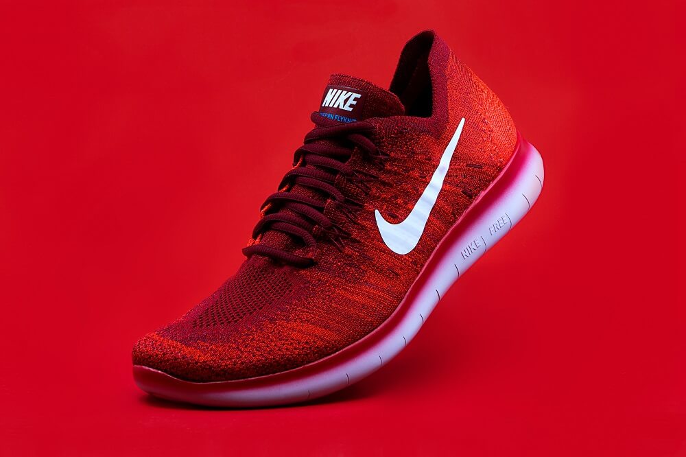 Product photography of a red nike shoe on red backdrop