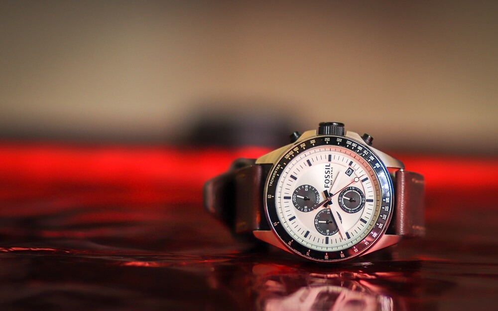 Product photography shot of a Fossil watch, on red background