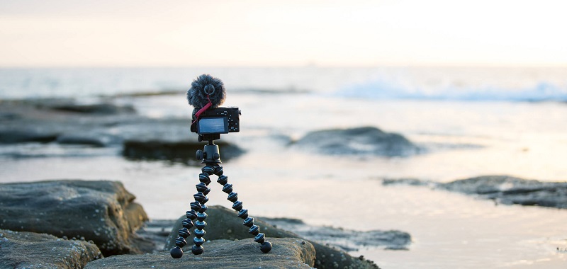 a digital camera attached to a flexible tripod placed on the beach