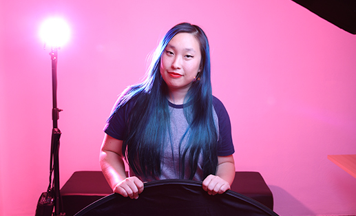 woman with blue hair lit by a studio light