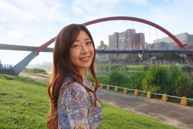 Smiling woman with bridge on the background, taken using the Sony ZV-1